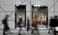 People walk past a Dior store