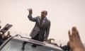 Mohamed Ould Ghazouani standing in a car waving to supporters.