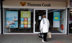 Woman looking into a closed Thomas Cook store