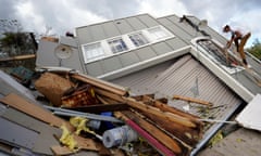 A man climbs up the side of his family’s destroyed storage unit after Hurricane Ida, in Houma, Louisiana, in August 2021.