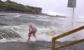 A swimmer is hit by a wave as he enters the water at at Clovelly beach in Sydney as severe weather brings strong winds and heavy rain along eastern coast of Australia.