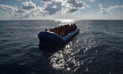 Migrants and refugees seated on a rubber boat wait to be evacuated during a rescue operation by the crew of the Topaz Responder, a rescue ship run by Maltese NGO "Moas" and the Italian Red Cross, on November 4, 2016 off the Libyan coast.