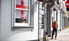 A man outside a pub in Barnsley with a St George’s Cross in the window