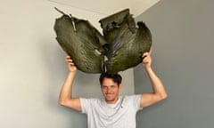 A man holds a large piece of seaweed over his head