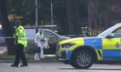 Police and a forensic investigator at the scene after a man was shot outside Ascot Drive police station in Derby