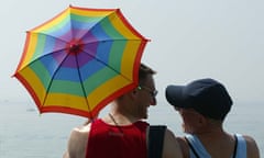 Gay couple with rainbow umbrella at Brighton seaside