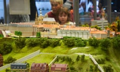 Prague’s Kingdom of Railways features model trains running around miniature versions of Czech cities. A mother and her daughter watch one run around Prague castle.