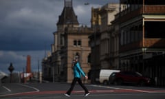 A person wearing a face mask crosses a road in Ballarat, Victoria