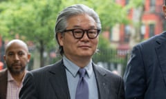 Man wearing black glasses, grey suit and purple tie