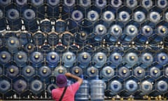 Man puts empty water containers back on a truck in Caracas, Venezuela.