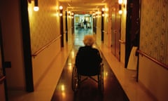 Elderly Woman in Assisted Care Home<br>A woman in a wheelchair looking down a long dark corridor of an aged care home