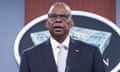 Black man with glasses wearing suit and grey tie.