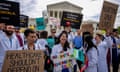 people with signs, some of them wearing medical coats