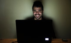 Happy young man on laptop computer smiling