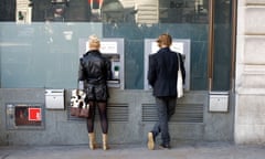 People withdrawing cash from a bank dispenser