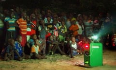 Villagers in La Pointe Saint-Georges, Senegal, gather for an open-air nightime film screening using Vincent Hanrion's bicycle-powered cinema system.