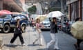 People sheltering from the sun under umbrellas cross a street during a heatwave in Bangkok, Thailand, last week.