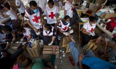 Volunteers from the Mexican Red Cross treat the blistered and cut feet of Central American migrants as a caravan of thousands stops for the night in Arriaga, Mexico, Friday, Oct. 26, 2018. Many migrants said they felt safer traveling and sleeping with several thousand strangers in unknown towns than hiring a smuggler or trying to make the trip alone.(AP Photo/Rebecca Blackwell)