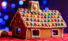 Gingerbread house decorated with colorful candies over Christmas tree lights background<br>MNR655 Gingerbread house decorated with colorful candies over Christmas tree lights background