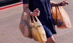 A shopper carries bags outside a Kroger grocery store