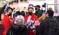 Cabin crew dress in red outfits and wearing face masks