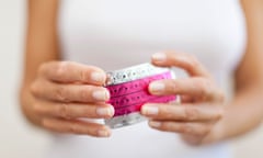 Woman’s hand holding birth control pills