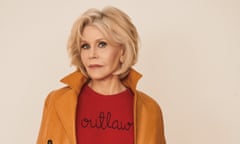 Jane Fonda wearing a red jumper with Outlaw written on it and a coat with the collar turned up