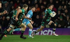 Northampton’s George Furbank runs with the ball, chased by a Sale player, before scoring a try.