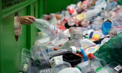 A plastic bottle is put into a recycling bin