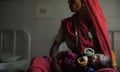 A new born baby sleeps in the arms of her mother at a Community Health Center in Mall, near Lucknow, India.