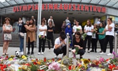 People mourn in front of candles and flowers  near the Olympia shopping mall in Munich