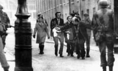 Father Edward Daly holds a white handkerchief as he helps clear a path for the injured on Bloody Sunday.