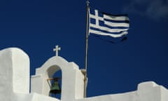 Greek flag above white church blue sky