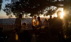 Revellers drinking on a terrace against the scenic backdrop at sunset in Lisbon
