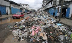 Liberians pass rubbish dumped in the streets of the capital, Monrovia.