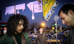 Iranians walk past electoral posters in downtown Tehran.