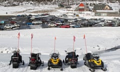 Skidoos parked on mostly empty ski runs at Perisher