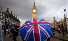 TOPSHOT-BRITAIN-EU-POLITICS-BREXIT<br>TOPSHOT - A pedestrian shelters from the rain beneath a Union flag themed umbrella as they walk near the Big Ben clock face and the Elizabeth Tower at the Houses of Parliament in central London on June 25, 2016, following the pro-Brexit result of the UK's EU referendum vote. The result of Britain's June 23 referendum vote to leave the European Union (EU) has pitted parents against children, cities against rural areas, north against south and university graduates against those with fewer qualifications. London, Scotland and Northern Ireland voted to remain in the EU but Wales and large swathes of England, particularly former industrial hubs in the north with many disaffected workers, backed a Brexit. / AFP PHOTO / JUSTIN TALLIS (Photo credit should read JUSTIN TALLIS/AFP/Getty Images)