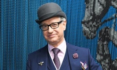 Man in bowler hat wearing a suit with brooches and a handkerchief in the breast pocket