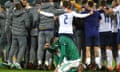 Northern Ireland’s Kyle Lafferty sinks to his knees as the Slovakia players celebrate the play-off win which qualifies them for Euro 2020.