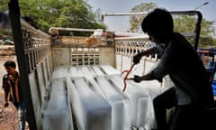 Workers transport ice from a factory in India 