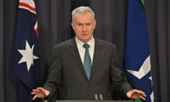 Australia's home affairs minister Tony Burke, standing in front of an Australian flag, speaking to media