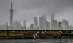 Three people stand in front of the Shanghai cityscape