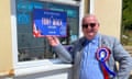 Tony Mack wearing a Reform rosette stood next to a sign advertising his candidacy in Clacton