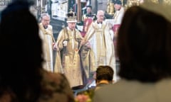 People watch a television screening of the coronation of King Charles III