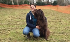 Kate Hurry kneeling in a field with a dog