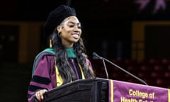 Teenage girl wearing doctorate graduation regalia stands in front of a podium