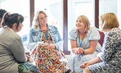 Four women sit in a group talking