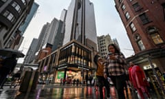 Shoppers make their way through the central business district on a rainy day in Sydney