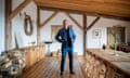 Kevin McCloud standing in a timber-framed kitchen with all-wood furniture